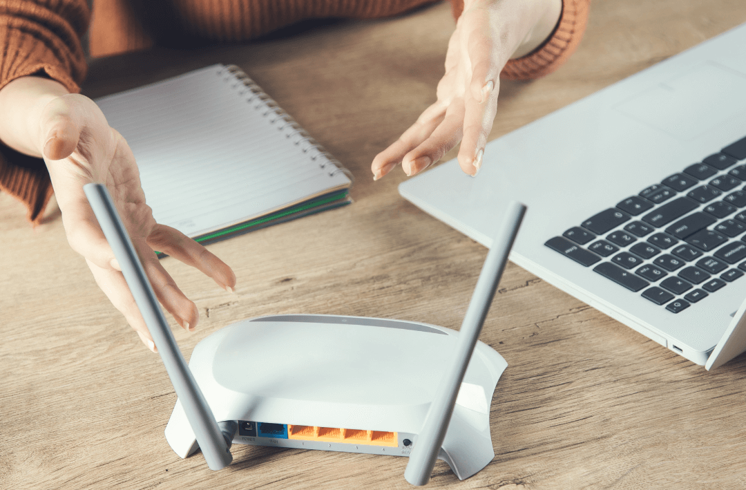 Adjusting router antenna near laptop for better Wi-Fi.